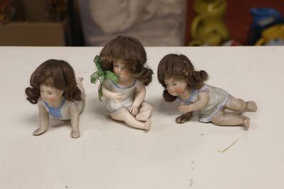three figurines of children sitting on a table