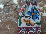 une photo d'un petit sac orné de perles sur lequel figure un oiseau