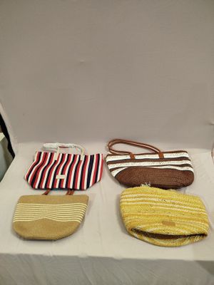 three purses sitting on a table with a white table cloth