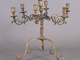 a brass candelab with four candles on it