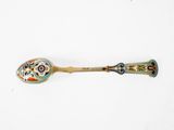 an old spoon with a decorative design on it sitting on top of a white surface