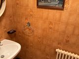 a bathroom with a sink, mirror, radiator and a picture on the wall