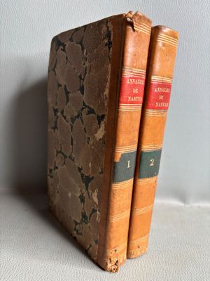 deux vieux livres posés l'un sur l'autre sur une table