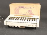un petit piano blanc avec une boîte posée sur la table