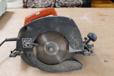 quelqu'un utilise une scie circulaire pour couper une pièce de bois