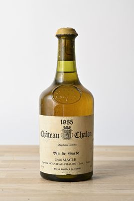 an old bottle of wine sitting on top of a wooden table