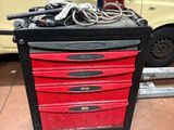 une boîte à outils rouge sur laquelle sont posés des outils, dans un garage