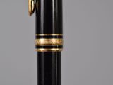 a close up of a pen with a gold band on it
