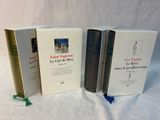 three books sitting on top of a white table next to each other