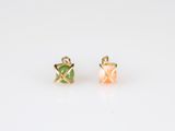 a pair of yellow and green earrings on a white surface