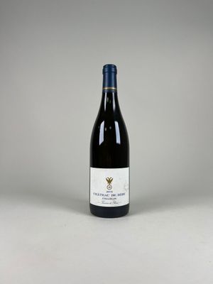 une bouteille de vin posée sur une table blanche