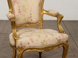 une image représentant une chaise dorée dont l'assise est recouverte d'un tissu à motifs floraux