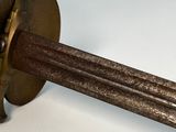 a small metal object with a wooden handle on a white surface