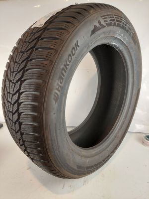 un gros plan d'un pneu posé sur une surface blanche, à côté d'une paire de ciseaux