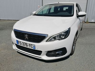 la voiture blanche est garée devant un bâtiment