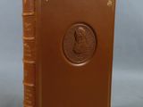 an old book with a brown cover sitting on top of a table