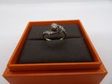 an orange box with a ring inside of it on a white surface
