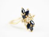 gros plan d'une bague en or avec des pierres bleues et blanches
