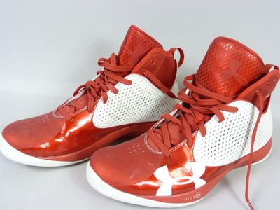 red and white under armour basketball shoes on a white surface