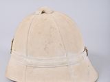 an old helmet is sitting on top of a white surface