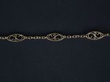 a close up of a silver bracelet with a chain on a black background