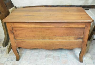 un petit coffre en bois posé sur le sol à côté d'une chaise