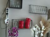 two vases with flowers on a table in front of a wall