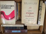 de nombreux livres dans une boîte en carton posée sur une étagère