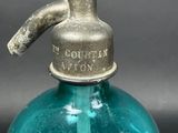 a blue glass bottle with a metal spigor attached to it