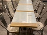une longue table entourée de six chaises dans une pièce