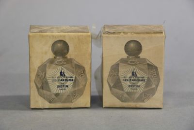 two boxes of perfume sitting on a table with a white background