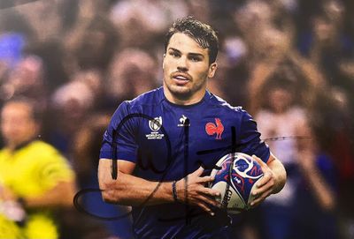 rugby player holding a ball in front of a crowd of people