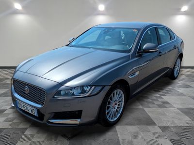 a grey jaguar parked in a room with a checkered floor