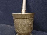brass mortar with a wooden handle on a black background