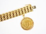 Gros plan sur un bracelet en or orné d'une pièce de monnaie
