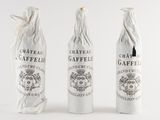 three bottles of wine are lined up in a row on a white surface
