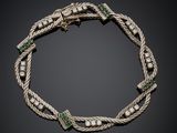 un bracelet en argent orné d'émeraudes et de perles sur fond noir