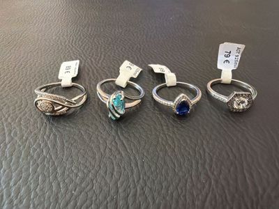 four different rings are sitting on a leather surface