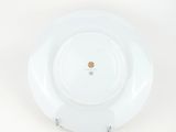 a white plate with a gold medallion on it