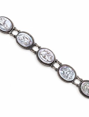 un gros plan d'un bracelet en argent orné de pièces romaines