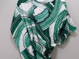 a green and white shirt hanging on a hanger on a wall