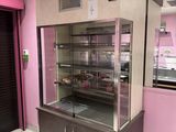 a display case in the middle of a room with pink walls