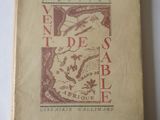 un vieux livre posé sur une table à côté d'une table blanche