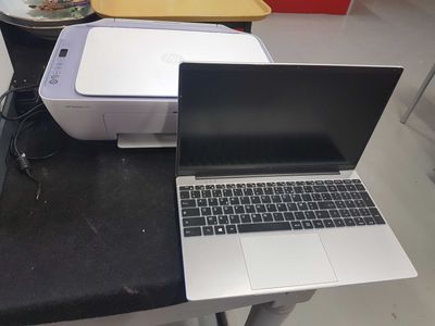two laptops sitting on a table next to a printer