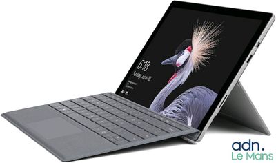 un gros plan d'un ordinateur portable avec un clavier posé dessus