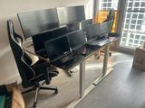 trois écrans d'ordinateur posés sur un bureau devant une fenêtre
