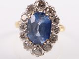 an image of a blue sapphire and diamond ring on a white surface