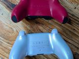 two video game controllers sitting on a wooden floor