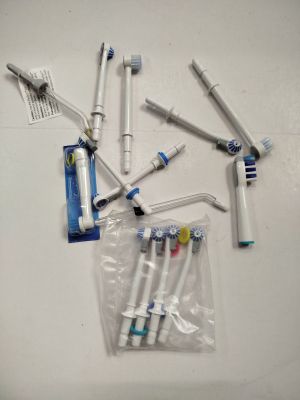 Plusieurs brosses à dents sont alignées sur une surface blanche