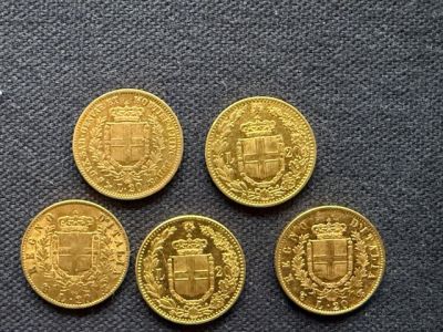 four gold coins with a coat of arms on them sitting on a table